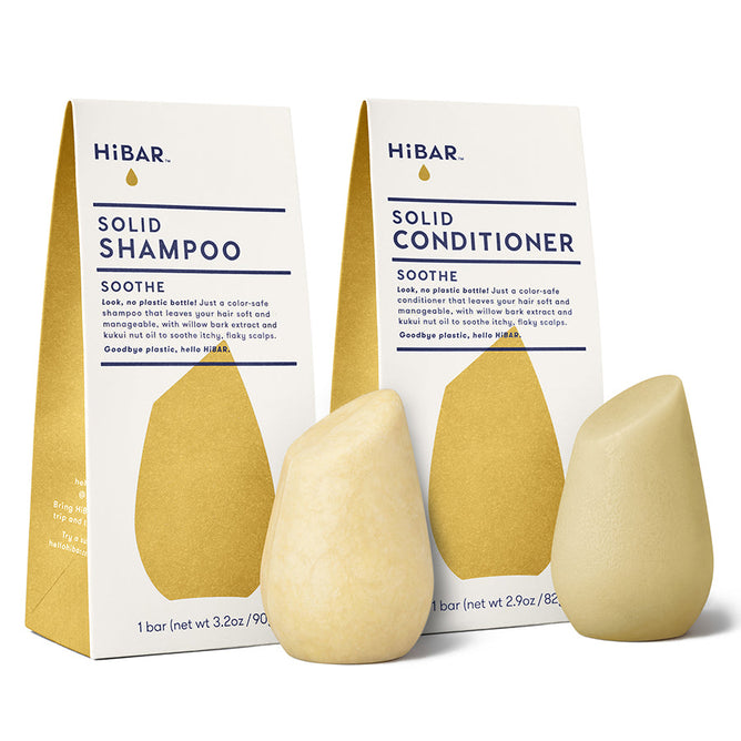 The HiBAR Soothe Solid Shampoo & Conditioner Set features teardrop-shaped, color-safe bars with enriching white willow bark extract, packaged in gold and white.