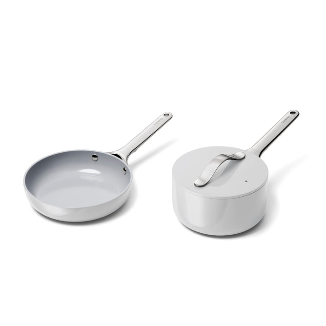 The Ceramic Mini Fry Pan & Mini Sauce Pan Duo by Caraway rests side by side on a white background, featuring sleek metal handles and a minimalist design with naturally non-stick, non-toxic ceramic coating for healthier cooking.