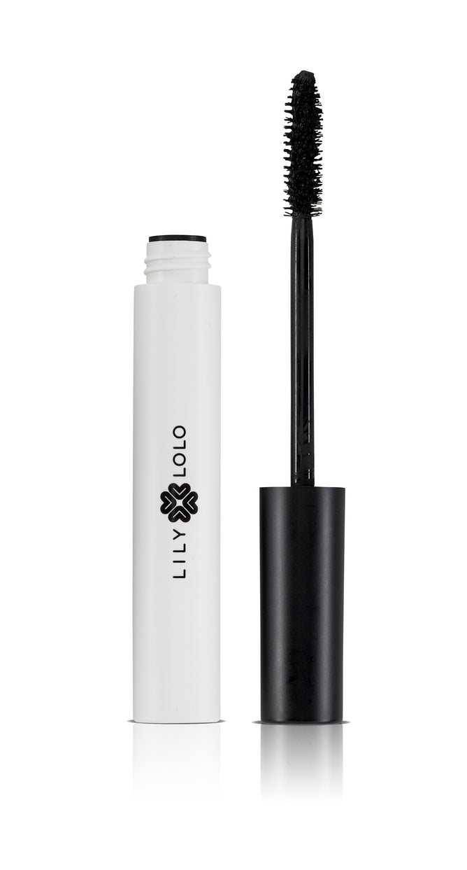 A white mascara tube from Lily Lolo is open, displaying the wand of their long-lasting Vegan Mascara. The tube, adorned with a black floral logo, sits gracefully on a clean white background.