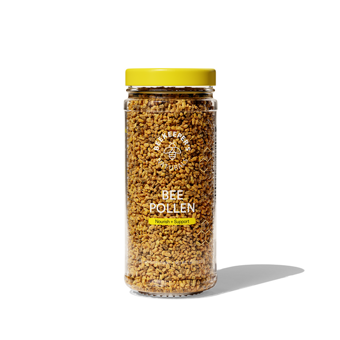 A clear jar with a yellow lid contains Bee Pollen from Beekeepers Naturals, labeled BEE POLLEN and Nourish + Support with a small bee logo. Often called Natures Multivitamin, the jar sits on a white background, casting a shadow.