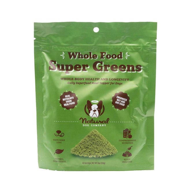 Green package labeled Super Greens Superfood Granules by Natural Dog Company. This Nutritional Feasts topper provides dogs with superfood granules, promoting whole-body health and nutrition using natural ingredients. Includes a dog silhouette and nutritional claims.