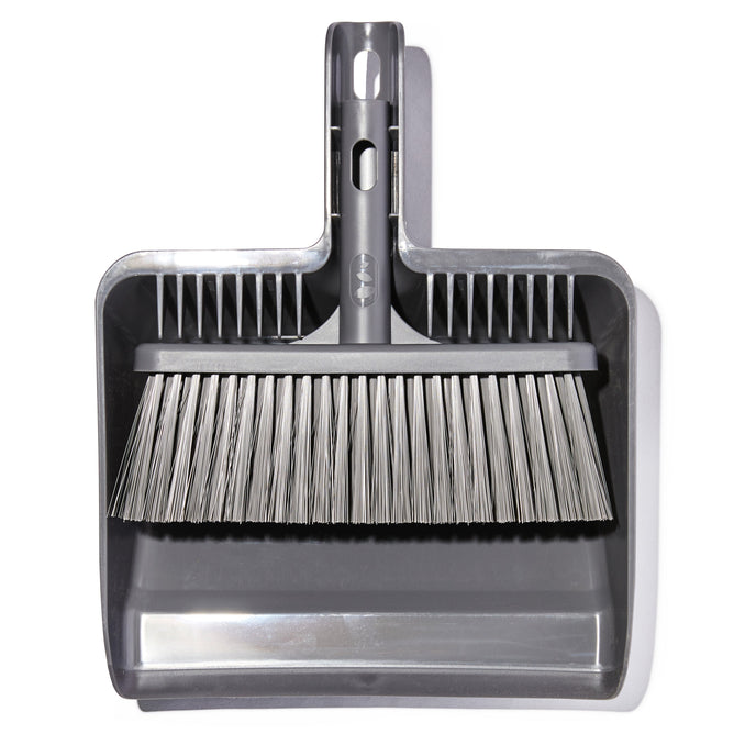 The Grove Co. Replaceable Broom Head and Dustpan Attachment, made from recycled materials, features a gray dustpan with an integrated brush snapped into the handle. The neatly aligned bristles above the dustpan are shown against a white background, ready for cleaning tasks.