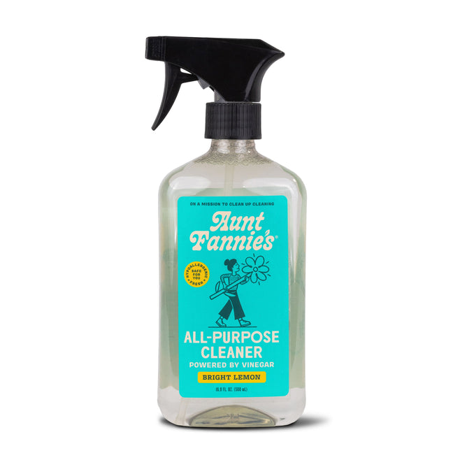 Aunt Fannies All-Purpose Cleaner, in Bright Lemon scent, comes in a spray bottle with a turquoise label and a flower-holding person illustration. Powered by vinegar and essential oils, it offers 16 fl oz (473 mL) of refreshing clean.