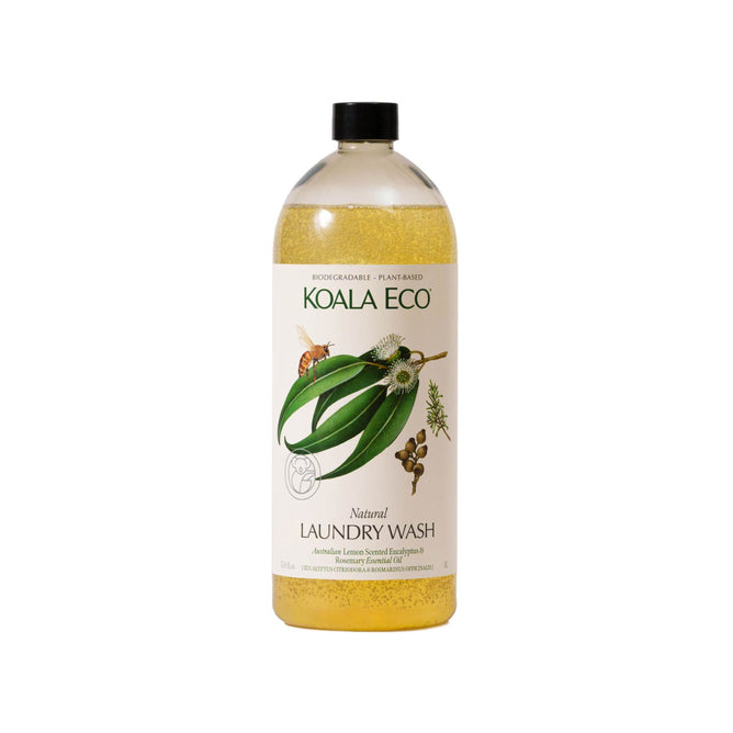The Koala Eco Laundry Wash features a yellow liquid, its label decorated with green leaves, flowers, and nuts. It boasts a plant-based, biodegradable formula with non-toxic ingredients and Australian essential oils. The bottle is topped with a black cap.