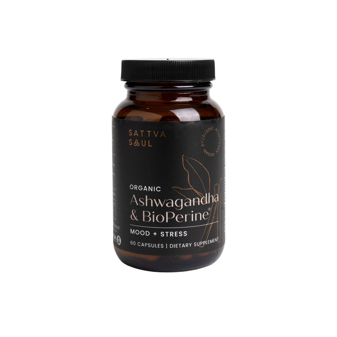 A dark brown bottle of Sattva Souls Organic Ashwagandha & Bioperine dietary supplement for mood and stress is shown, featuring a label that emphasizes its Ayurvedic medicine benefits and contains 60 capsules.
