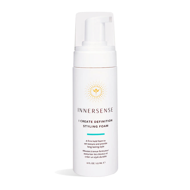 The Innersense Organic Beauty I Create Definition Styling Foam comes in a white 6 fl oz (177 mL) bottle with a pump dispenser and a gold circular design near the top. Infused with aloe leaf juice, it offers firm hold for long-lasting, frizz-free curls.