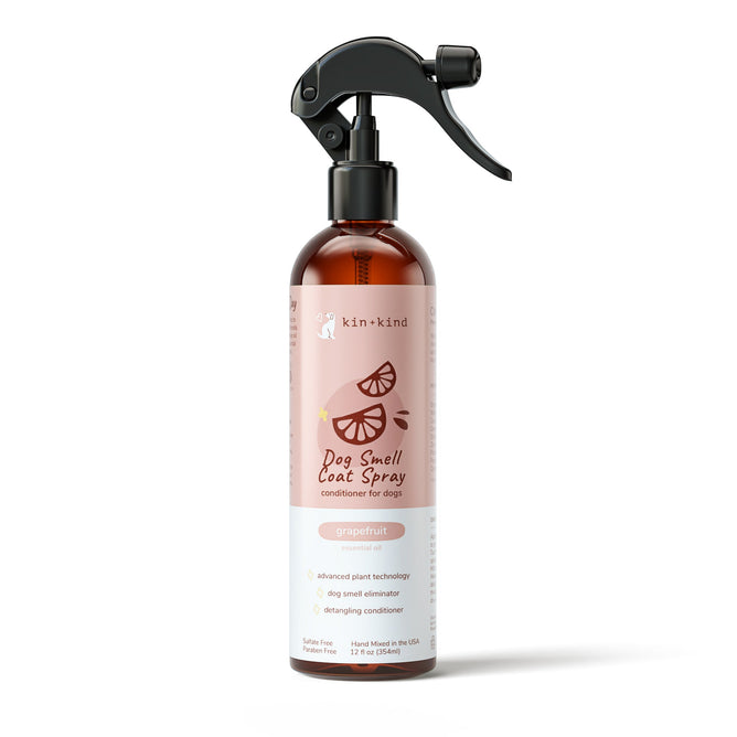 The kin+kind Grapefruit Coat Spray for Dog Smells features a black spray nozzle and a pink label with citrus graphics. It naturally neutralizes odors, conditions, and detangles dog fur using advanced plant technology. The bottle contains 12 fl oz (354 mL).