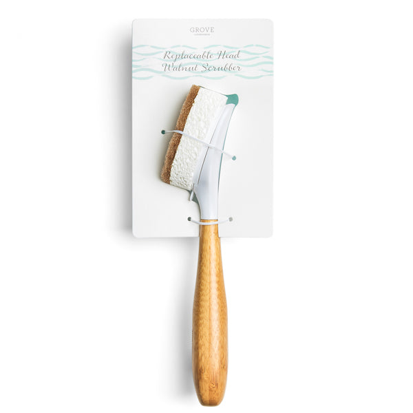 Grove Co.s Replaceable Head Walnut Scrubber Dish Brush features a bamboo handle and replaceable white non-abrasive cleaning head with a brown edge, combining sponge and brush benefits. Its neatly presented in white packaging.