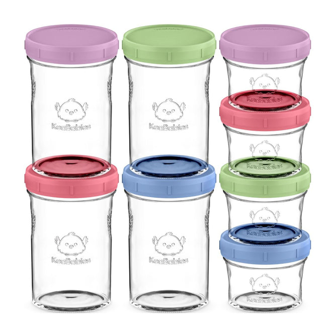 The Glass Baby Food & Snack Storage Containers by KeaBabies include eight clear jars with colorful lids in pink, green, red, and blue, each featuring a cute baby face logo. These sustainable products are stacked in two rows to showcase the variety of vibrant lid colors.