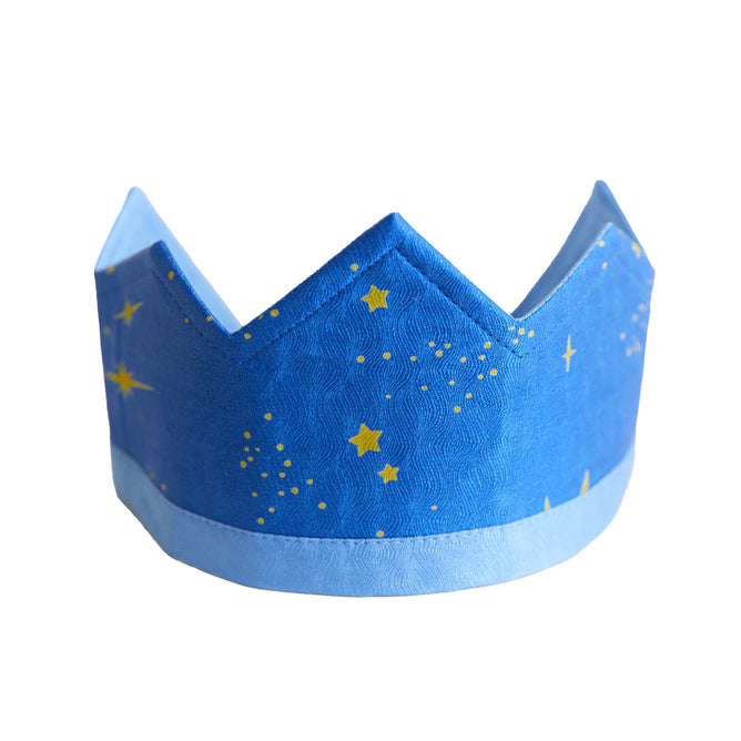 The Star Crown by Sarahs Silks, featuring a blue paper design with yellow stars and dots, rests on a white background—ideal for imaginative play.