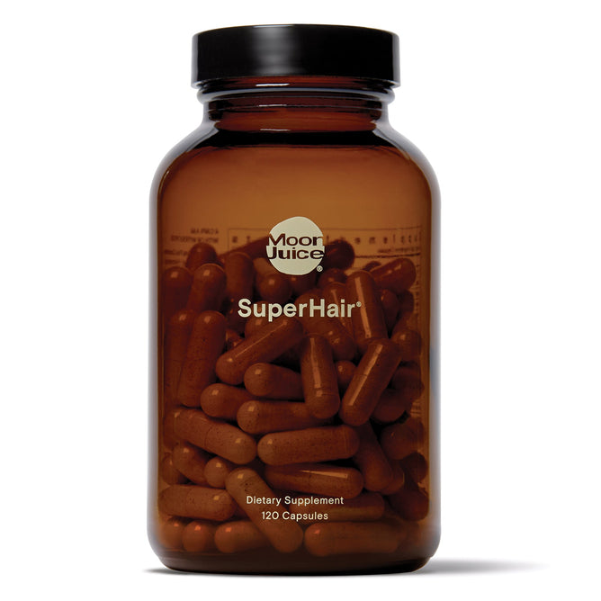 A brown glass bottle labeled Moon Juice SuperHair - Multivitamin + Hair Magic contains 120 capsules designed with a powerful formula to support healthier hair and enhance its natural vitality.