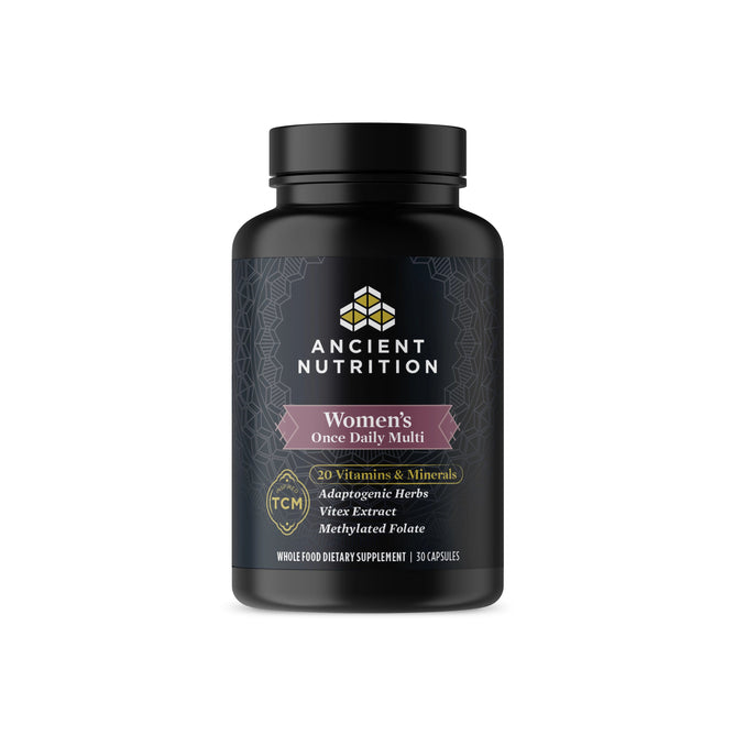 A bottle of Ancient Nutritions Ancient Multi - Womens Once Daily, tailored for prenatal and postpartum health, contains 30 capsules with adaptogenic herbs, vitex extract, and methylated folate. The black label is decorated with white and pink geometric patterns.