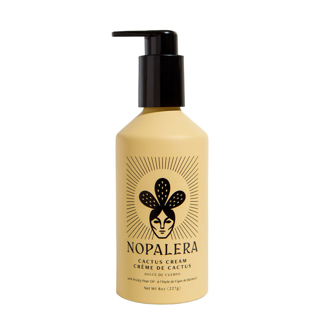 The NOPALERA Cactus Body Cream comes in an 8 oz (227g) beige bottle with a black pump dispenser. Its label features a stylized woman with cactus motifs, showcasing the anti-inflammatory and hydrating benefits of prickly pear oil.
