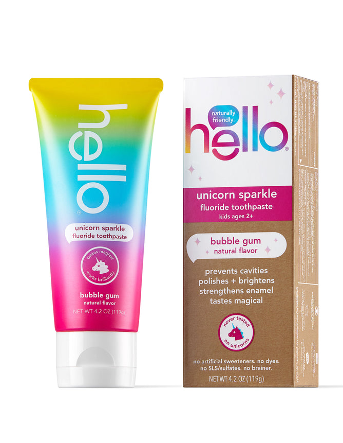 A colorful tube of hello Kids Unicorn Sparkle Fluoride Toothpaste with natural bubble gum flavor sits beside its box. Designed for kids aged 2+, this vegan toothpaste showcases a playful gradient of yellow, pink, and blue with vibrant text.