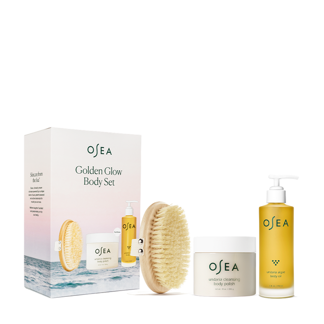 The OSEA Golden Glow Body Care Starter Set includes a dry brush, Undaria Cleansing Body Polish, and Undaria Algae Body Oil for deep moisturization. Its minimalist packaging and ocean-themed design enhance the golden glow experience.