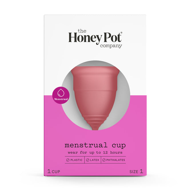 Image of The Honeypot Companys Silicone Menstrual Cup in packaging: a white and pink box with a clear window. Its made of medical-grade silicone, free from plastic, latex, and phthalates, offering a sustainable alternative for up to 12 hours of wear.
