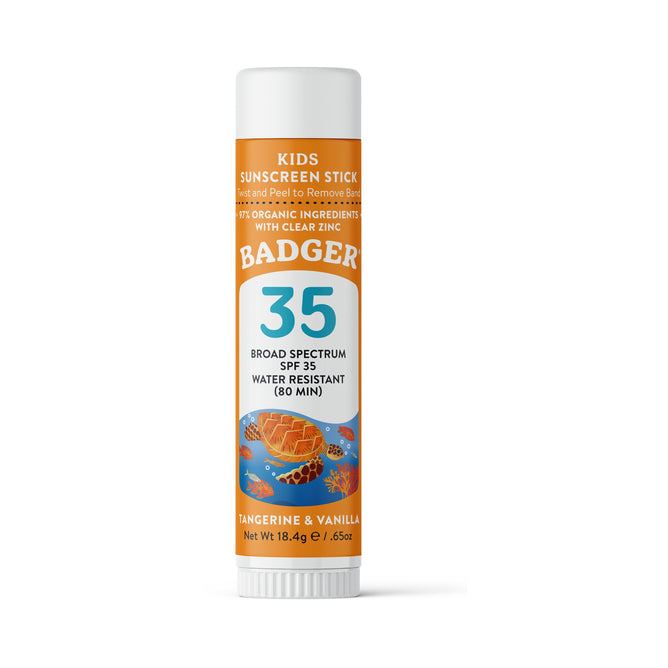A cylindrical tube of Badger Balm Kids Mineral Sunscreen Face Stick SPF 35 features natural zinc oxide. The orange packaging with a honeycomb and flowers design is labeled broad spectrum, water-resistant for 80 minutes, gentle on sensitive skin, and scented with tangerine and vanilla.