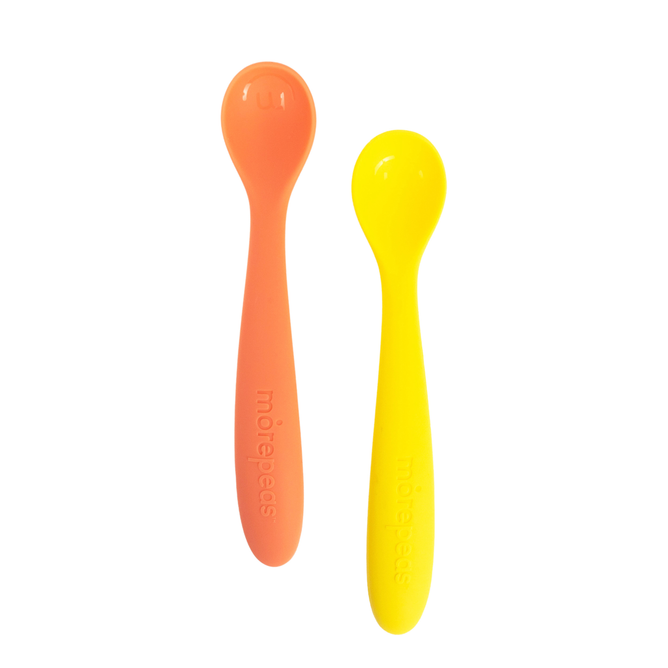 Featured are two Baby to Tot Spoons by morepeas, one orange and one yellow. Crafted from food-grade silicone, these utensils have long handles and rounded tips, displayed side by side on a white background.