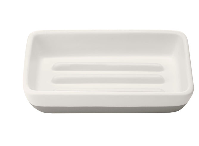 The Full Circles Raise the Bar Soap Holder, a white rectangular ceramic piece with ridged grooves, adds elegance and complements eco-friendly living—ideal for sustainability enthusiasts.