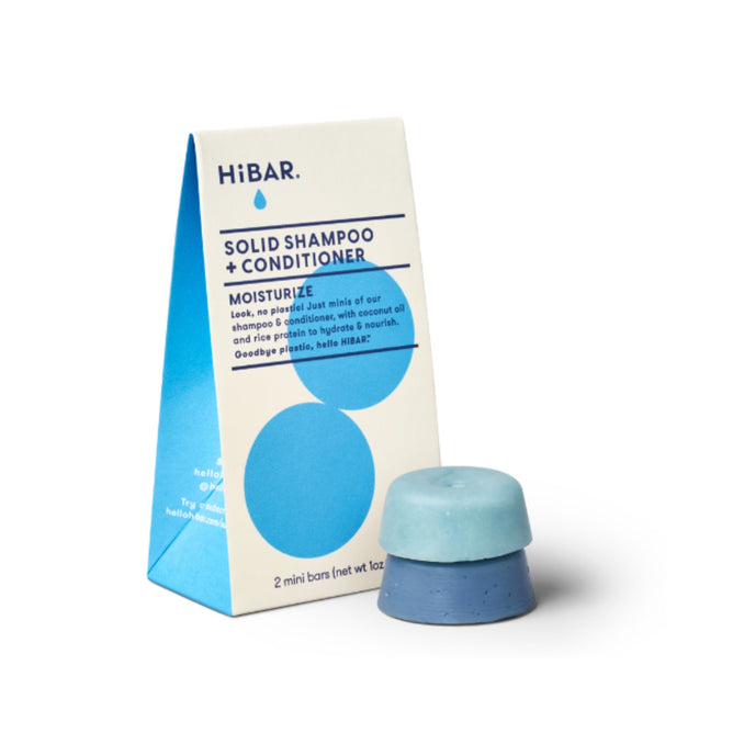 The HiBAR Moisturize Sampler Set features mini solid blue shampoo and conditioner bars beside their rectangular, pyramid-shaped packaging. The plastic-free design displays the HiBAR logo and advertises the set as a moisturizing shampoo and conditioner duo.