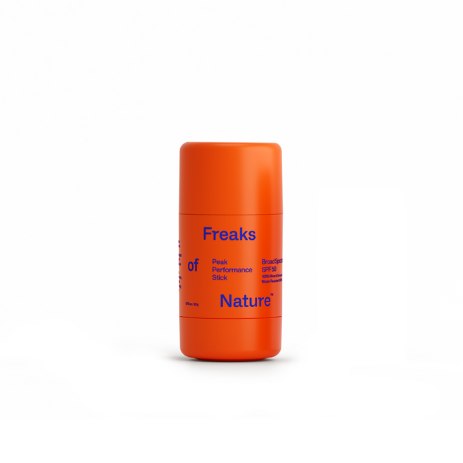An orange cylindrical Peak Performance Sun Stick SPF50 by Freaks of Nature, labeled with blue and orange text, features microalgae Oil™ for advanced UV protection. The stick stands upright on a white background.