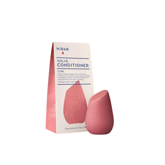 The Curl conditioner bar by HiBAR, with its pink packaging labeled HiBAR Solid Conditioner Curl, is ideal for curly hair care; the box stands upright beside the distinctively shaped, moisturizing product to display details and branding.