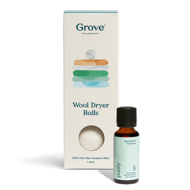 A Grove Co. Wool Dryer Balls box featuring pastel geometric shapes sits next to a small dark bottle labeled Purify, highlighting all-natural peppermint and eucalyptus essential oils with a green label.