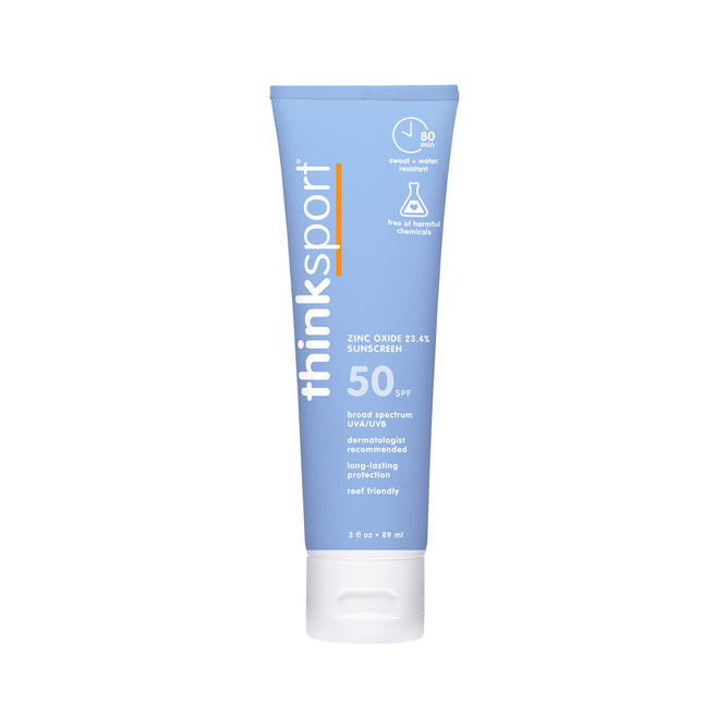 A light blue tube of thinksun thinksport SPF 50 mineral sunscreen with white text highlighting broad spectrum, zinc oxide, and reef-friendly for sensitive skin, stands upright on a white backdrop.
