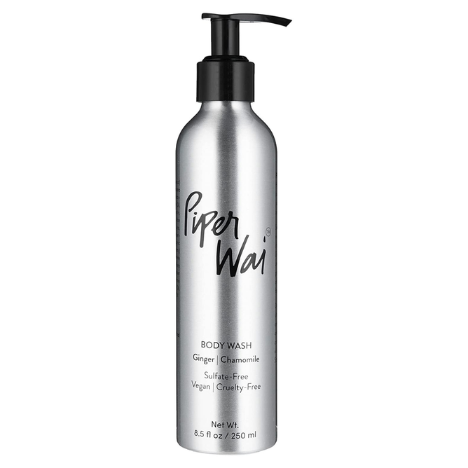A silver bottle with a black pump dispenser labeled PiperWai Body Wash displays Ginger | Chamomile, and notes its Sulfate-Free, Vegan, and Cruelty-Free. Infused with Moringa Oil for nourishment, the volume is 8.5 fl oz (250 ml).