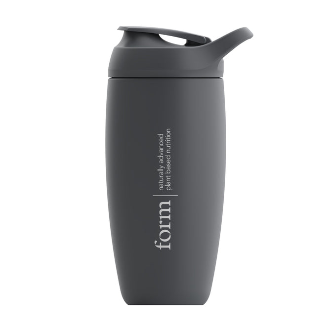The Form Insulated Shaker Bottle by Form Nutrition is a sleek, matte dark gray bottle with a screw-on lid and flip-top spout. Its vacuum-insulated to keep protein shakes cold. The phrase form, naturally advanced plant-based nutrition is printed vertically on its side.