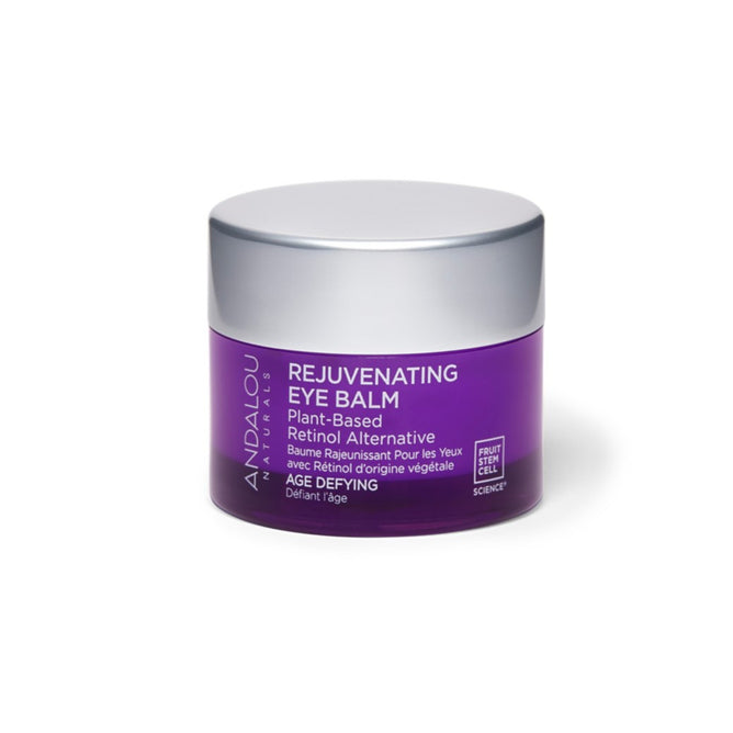 A purple container of Andalou Naturals Age Defying Rejuvenating Retinol Alternative Eye Balm with a silver lid prominently features Bakuchiol as an age-defying, plant-based retinol alternative on its label.