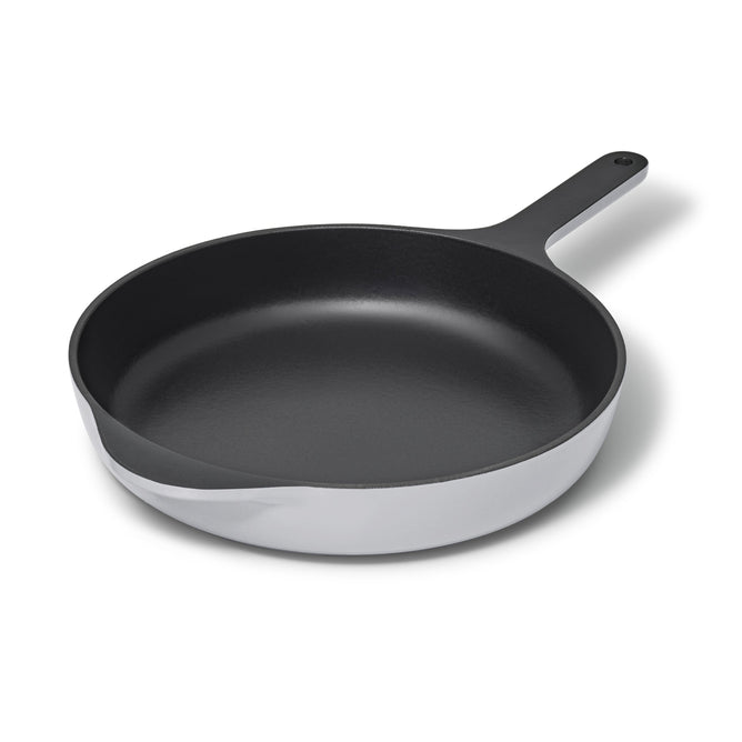 Caraways 10.5 cast iron skillet in black enamel features a long handle and smooth interior, shown against a white background. Its modern design ensures superior heat retention for even cooking.