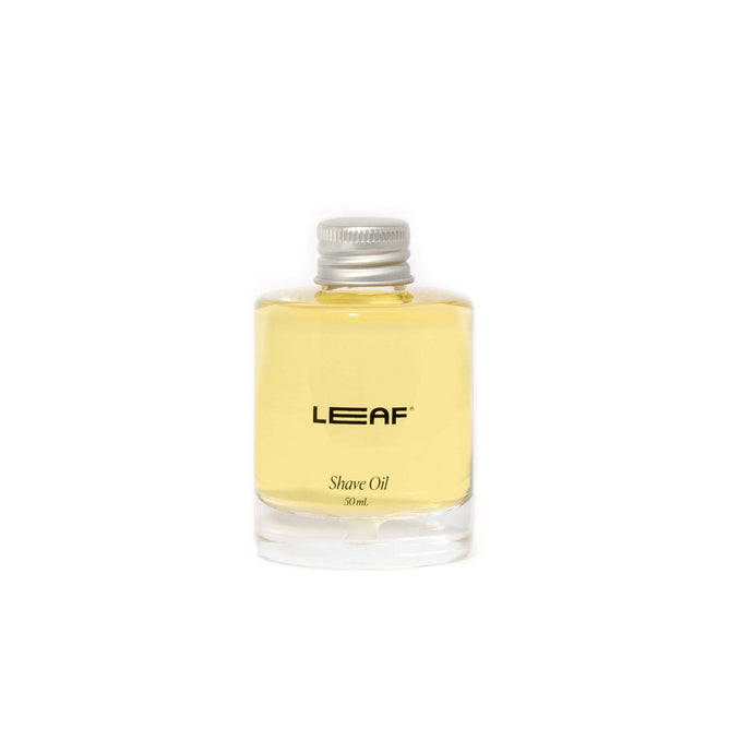 A small clear bottle with a silver cap contains yellow liquid and is labeled Shave Oil Refill, Leaf Shave 30ml. It provides skin-soothing antioxidants for a calming experience.