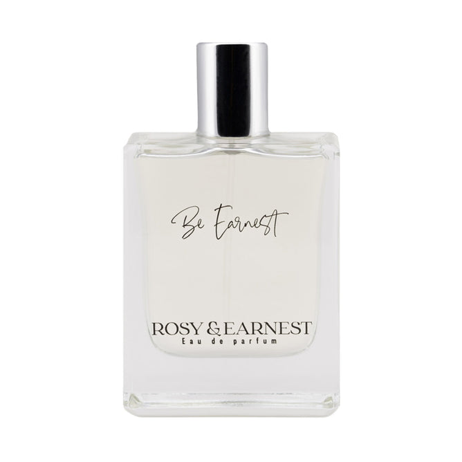 The Be Earnest perfume by Rosy & Earnest is a clear bottle capped in silver, labeled elegantly with its name. Below, its marked Eau de Parfum. This vegan scent is light and transparent with a subtle woody aroma.