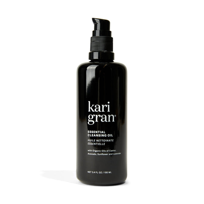 The 3.4 fl. oz. black pump bottle of Kari Grans Essential Cleansing Oil features organic oils like avocado, sunflower, and lavender for a hydrating cleanse and effective makeup removal.