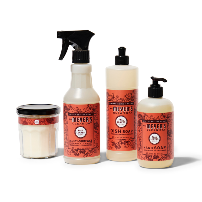 The Mrs. Meyers Fall Freshen Up Set includes a candle, multi-surface spray, dish soap, and hand soap in Fall Leaves scent, all featuring orange floral labels on white.
