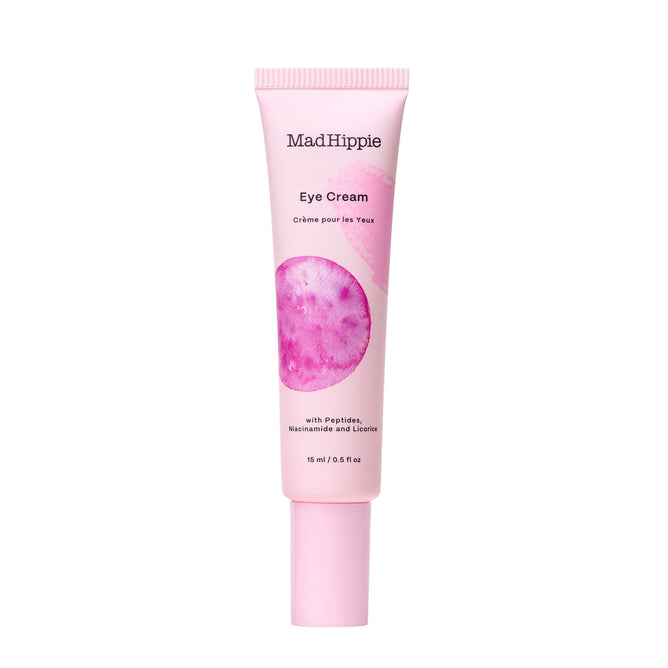 Pink tube of Mad Hippie Eye Cream features a circular floral design and bilingual text in English and French stating Crème pour les Yeux. Packed with peptides and antioxidants, it provides revitalizing care. Volume: 15 ml / 0.5 fl oz.