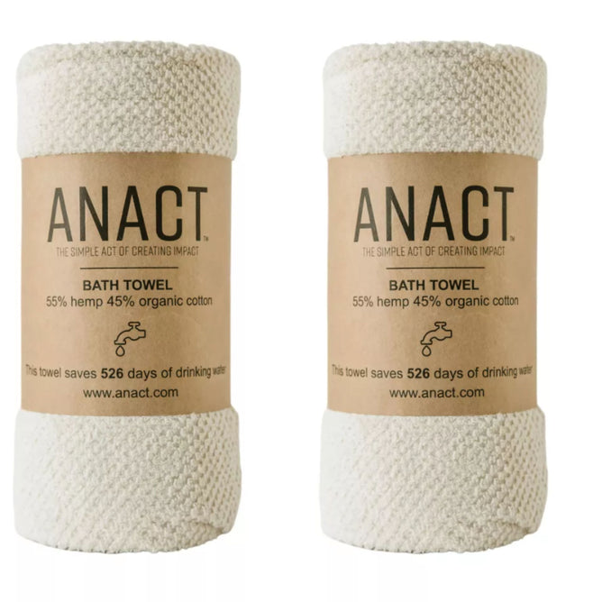 Two white bath towels wrapped in brown paper labels display the brand Anact. Made from 55% hemp and 45% organic cotton, these fast-drying towels claim to save 526 days of drinking water. Learn more about the Hemp and Organic Cotton Bath Towel Set at www.anact.com.