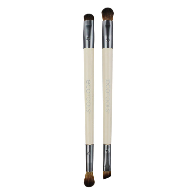 The EcoTools Eye Enhancing Duo Brush Set includes two double-ended makeup brushes with beige handles and silver ferrules aligned vertically. Each vegan brush has different heads for varied applications, with ecotools visible on the cruelty-free handles.
