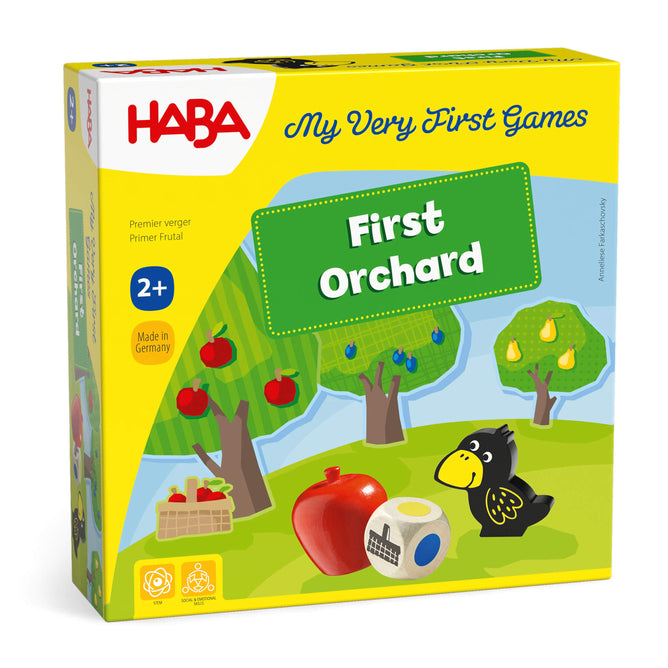 The My Very First Games - First Orchard by HABA comes in yellow packaging with orchard illustrations, fruit, a raven, a red apple, and a large die. This colorful cooperative game is ideal for early learning and suitable for ages 2+.