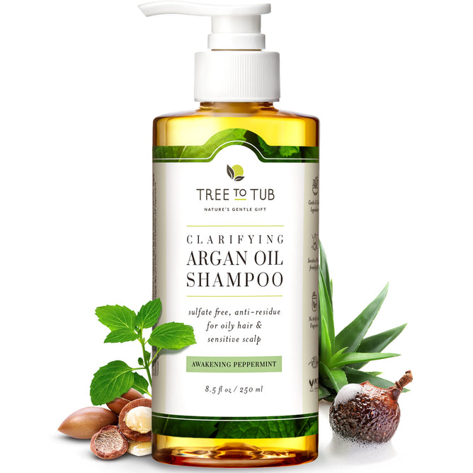 A bottle of Tree To Tub Clarifying Shampoo for Oily Hair & Sensitive Scalp with a pump dispenser features Tea Tree Oil, sulfate-free formulation, and anti-residue benefits. It includes imagery of argan nuts, peppermint leaves, and an unopened nut.