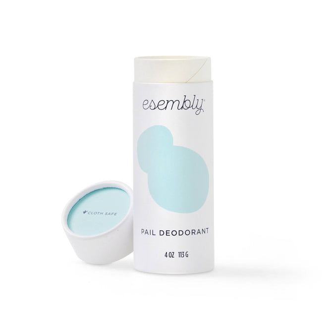 An upright cylindrical container of Esembly Babys Diaper Pail Odor Eliminator & Deodorizer, features a minimalist light blue and white design. The open lid reveals a Cloth Safe label, emphasizing its all-natural powder deodorizer formula.