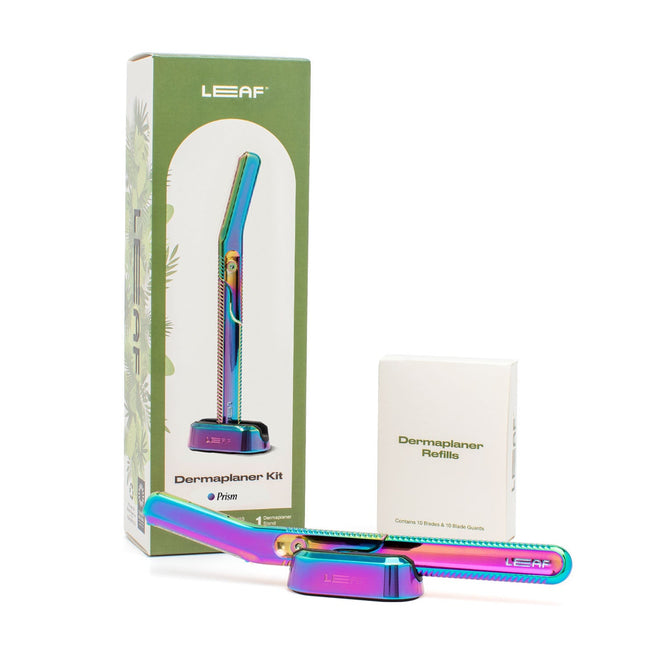 The Leaf Shave Dermaplaner Kit, featuring a prism-colored razor and refills designed for zero-waste exfoliation, comes in eco-friendly green packaging. The kit and refills are displayed neatly against a plain white background.
