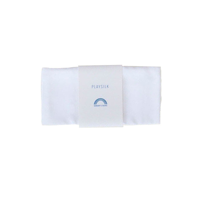 A neatly folded white playsilk from Sarahs Silks, ideal for creative play and DIY projects, is wrapped with a paper band displaying PLAY SILK and a small blue rainbow logo against a plain white background.