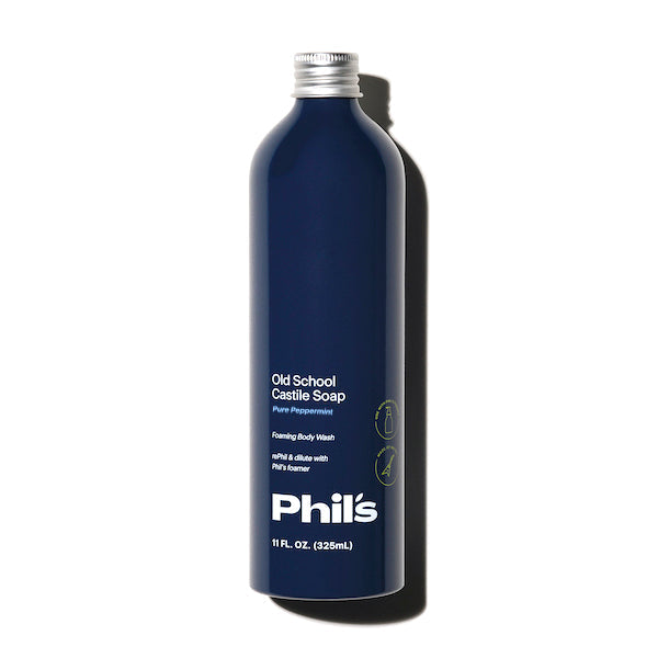 A navy Phils Old School Castile Soap bottle is shown on a white background. The label reads Pure Peppermint and Foaming Body Wash in white text. Ideal for a refreshing wash or versatile cleaner, it contains 11 fl. oz. (325 mL).