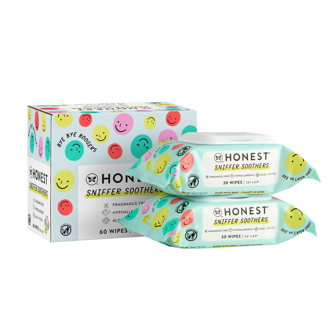The Honest Companys Sniffer Soothers Gentle Soothing Nose and Face Wipes are dermatologist-tested, fragrance-free, hypoallergenic, and come in packs of 60 or 30. Their packaging features a box with two packages adorned with colorful smiling faces.