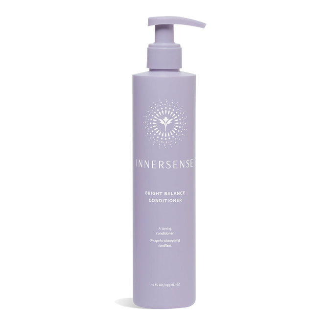 An Innersense Organic Beauty Bright Balance Conditioner in a 10 fl. oz. (295 ml) lavender bottle with a pump top and white sunburst design, offering a silicone-free formula to neutralize brassiness effectively.