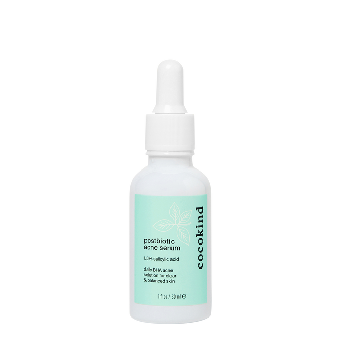 The Cocokind Postbiotic Acne Serum, featuring 1.5% salicylic acid, has a light green label and white dropper cap, and targets clogged pores for clearer skin.