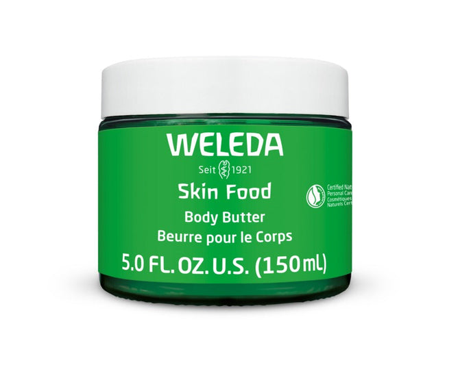 Weleda Skin Food Body Butter comes in a jar with a green label marked Seit 1921, and 5.0 FL. OZ. U.S. (150 ml), displaying certification logos, offering non-greasy hydration with shea and cocoa seed butters, and topped with a sleek white lid.