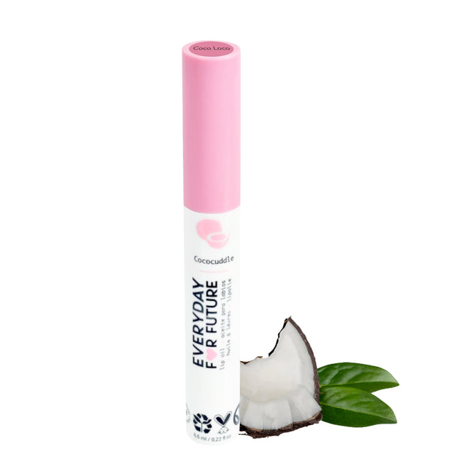A pink and white tube labeled Everyday For Future stands upright next to a coconut half and green leaves, showcasing the natural essence of the Moisturizing Coconut Lip Oil infused with nourishing Coconut Oil.